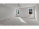 Spacious bedroom with soft carpet, two windows, neutral walls, and a ceiling fan for a comfortable and serene atmosphere at 145 Leisure Ln # 12, Louisburg, NC 27549