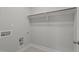 Bright laundry room with gray tile floor, utility connections and rod, designed for efficient laundry tasks at 145 Leisure Ln # 12, Louisburg, NC 27549