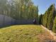 Serene backyard featuring a lush lawn, privacy fence, and mature trees at 150 Sherrill Place Ln, Garner, NC 27529