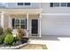 Inviting home featuring a covered entrance, black door, attached garage, and manicured landscaping at 150 Sherrill Place Ln, Garner, NC 27529