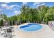 Relaxing backyard pool with lounge chairs, mature trees, and a black metal fence surround at 150 Sherrill Place Ln, Garner, NC 27529