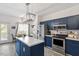 Modern kitchen with stainless steel appliances, dark blue cabinets, and center island at 1601 Dunraven Dr, Raleigh, NC 27612