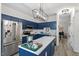 Kitchen with stainless steel appliances, white countertops, blue cabinets, and island with a modern light fixture at 1601 Dunraven Dr, Raleigh, NC 27612