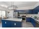 Modern kitchen with stainless steel appliances, dark blue cabinets, and center island at 1601 Dunraven Dr, Raleigh, NC 27612