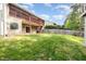 Open backyard with grass, fencing, and a home with a two-story deck at 2024 Spring Creek Dr, Durham, NC 27704