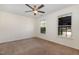 Spacious carpeted bedroom with large windows and a ceiling fan at 2024 Spring Creek Dr, Durham, NC 27704