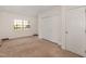 Carpeted bedroom features a window, closet with double doors, and a single door at 2024 Spring Creek Dr, Durham, NC 27704