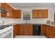 Bright kitchen with white tile floors, granite countertops, wood cabinets, and stainless steel appliances at 2024 Spring Creek Dr, Durham, NC 27704