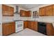 Cozy kitchen with white tile floors, wood cabinets, granite countertops, and stainless steel appliances at 2024 Spring Creek Dr, Durham, NC 27704