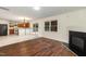 Open concept living room leading to kitchen with fireplace, hardwood floors, and lots of light at 2024 Spring Creek Dr, Durham, NC 27704