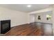 Open concept living room with fireplace and hardwood floors leading to another living area at 2024 Spring Creek Dr, Durham, NC 27704