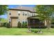 Back exterior featuring a cozy screened-in porch, well-maintained lawn, and mature landscaping at 2053 Monthaven Dr, Wake Forest, NC 27587