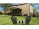 Relaxing backyard with lawn chairs, lush green grass, and view of the screened in porch at 2053 Monthaven Dr, Wake Forest, NC 27587