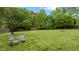 Spacious backyard featuring a wooden fence, lush lawn, two chairs, and mature trees at 2053 Monthaven Dr, Wake Forest, NC 27587