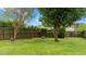 Scenic backyard showcasing a wooden fence, stone bench, lush lawn, and mature trees at 2053 Monthaven Dr, Wake Forest, NC 27587