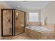 Modern bathroom featuring glass enclosed shower, corner bathtub, and travertine tile at 2053 Monthaven Dr, Wake Forest, NC 27587