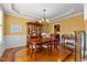 A dining room with a chandelier, wood floors and an entrance to a kitchen at 2053 Monthaven Dr, Wake Forest, NC 27587