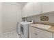 Well-organized laundry room with a sink, counter space, and white cabinetry at 2053 Monthaven Dr, Wake Forest, NC 27587