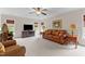 Spacious living room featuring a ceiling fan, plush carpet, and comfortable leather seating at 2053 Monthaven Dr, Wake Forest, NC 27587