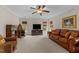 Bright living room with a leather sofa, cozy armchair, and a large television at 2053 Monthaven Dr, Wake Forest, NC 27587