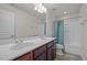 Bathroom featuring double vanity, blue shower curtain, white cabinets and bathtub with shower at 209 Oswego Ct, Morrisville, NC 27560