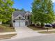 Two-story home with a two-car garage, well-maintained yard, and mature trees at 209 Oswego Ct, Morrisville, NC 27560
