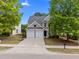 Inviting two-story home with a two-car garage, mature trees, and a well-kept lawn at 209 Oswego Ct, Morrisville, NC 27560