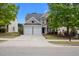 Inviting two-story home with a two-car garage, manicured lawn, and mature trees at 209 Oswego Ct, Morrisville, NC 27560