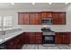A kitchen is equipped with wooden cabinets, stainless steel appliances, and light countertops at 209 Oswego Ct, Morrisville, NC 27560