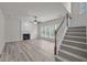 A living room with a decorative fireplace, three windows, and carpeted stairs at 209 Oswego Ct, Morrisville, NC 27560