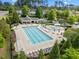 Aerial view of the community pool showcasing lounge seating, umbrellas, and nearby mature trees at 209 Oswego Ct, Morrisville, NC 27560