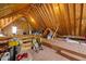 Unfinished attic space with exposed beams, a window, and a ceiling fan for ventilation at 210 Highlands Lake Dr, Cary, NC 27518