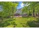 Lush backyard featuring a sprawling lawn, mature trees, and a patio for relaxing and entertaining at 210 Highlands Lake Dr, Cary, NC 27518