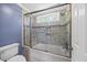 Bathroom showcasing tiled walls, a shower with glass doors and a window above a bathtub at 210 Highlands Lake Dr, Cary, NC 27518