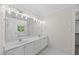 Bright bathroom features double sinks, a large mirror with lights, and tiled floors at 210 Highlands Lake Dr, Cary, NC 27518