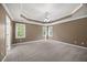 Spacious bedroom featuring carpet, tray ceiling, ceiling fan, and natural light from windows at 210 Highlands Lake Dr, Cary, NC 27518