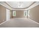 Spacious bedroom with carpet, tray ceiling, ceiling fan, and natural light from windows at 210 Highlands Lake Dr, Cary, NC 27518