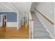 Inviting entryway featuring hardwood floors, a staircase, and white trim at 210 Highlands Lake Dr, Cary, NC 27518
