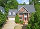 Classic brick home with an attached garage, mature trees, and attractive landscaping at 210 Highlands Lake Dr, Cary, NC 27518