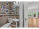 Unique powder room featuring library-themed wallpaper and pedestal sink at 210 Highlands Lake Dr, Cary, NC 27518