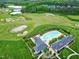Community aerial shot showing a pool, tennis courts, golf course, and clubhouse amid lush greenery at 213 North Crest Dr, Chapel Hill, NC 27517