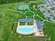 Aerial view showcases community pool, tennis courts, clubhouse, parking, and surrounding green spaces at 213 North Crest Dr, Chapel Hill, NC 27517