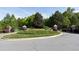 Inviting circular entrance with landscaped greenery, colorful flowers, and stone-pillar adorned gates in the Legacy community at 213 North Crest Dr, Chapel Hill, NC 27517