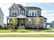 Beautiful two-story home featuring stone accents, a welcoming front porch and lush green lawn on a sunny day at 213 North Crest Dr, Chapel Hill, NC 27517