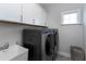 Modern laundry room features stainless steel washer and dryer plus white cabinets and sink at 213 North Crest Dr, Chapel Hill, NC 27517