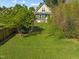 Aerial view of backyard featuring lush green grass, a storage shed, and mature trees at 215 Haywood St, Raleigh, NC 27601