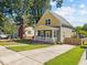 Charming home featuring a yellow and gray exterior, a welcoming front porch, and a well-maintained front yard at 215 Haywood St, Raleigh, NC 27601