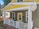 Inviting porch featuring a yellow door, white railing, and cozy seating at 215 Haywood St, Raleigh, NC 27601