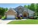 Charming brick home featuring a well-manicured lawn, mature landscaping, and a two-car garage at 226 Marshview Cir, Angier, NC 27501