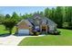 Beautiful brick home with lush green lawn and mature trees creating a serene and inviting atmosphere at 226 Marshview Cir, Angier, NC 27501